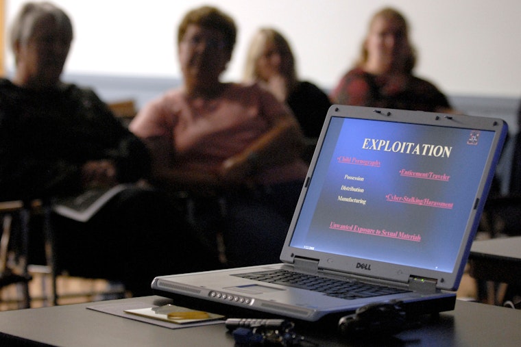 Parents sit during a presentation