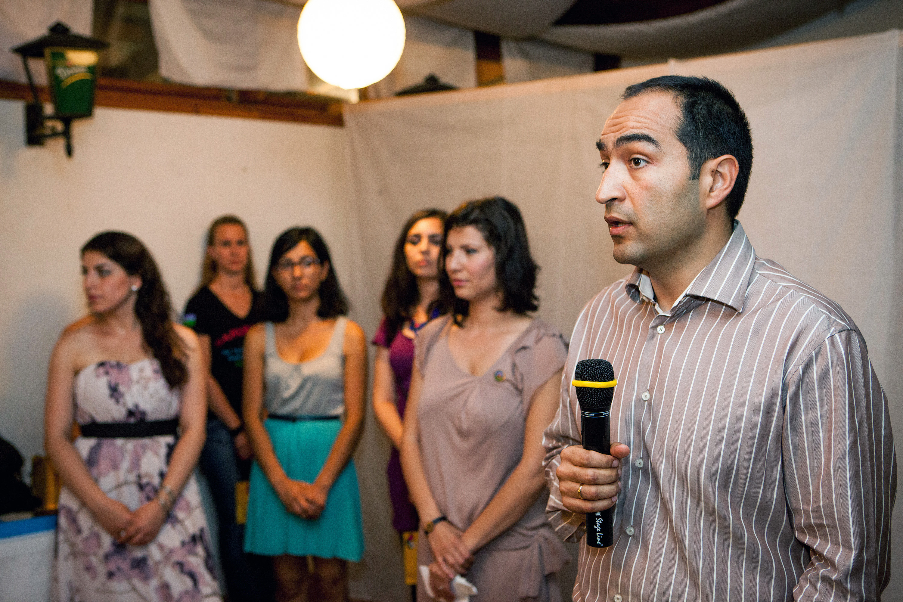 Man speaks in microphone beside small group
