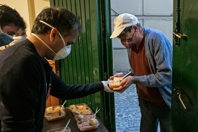 A man accepts food from a soup kitchen