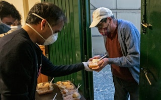 A man accepts food from a soup kitchen