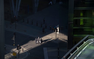 People crossing a street near an office building