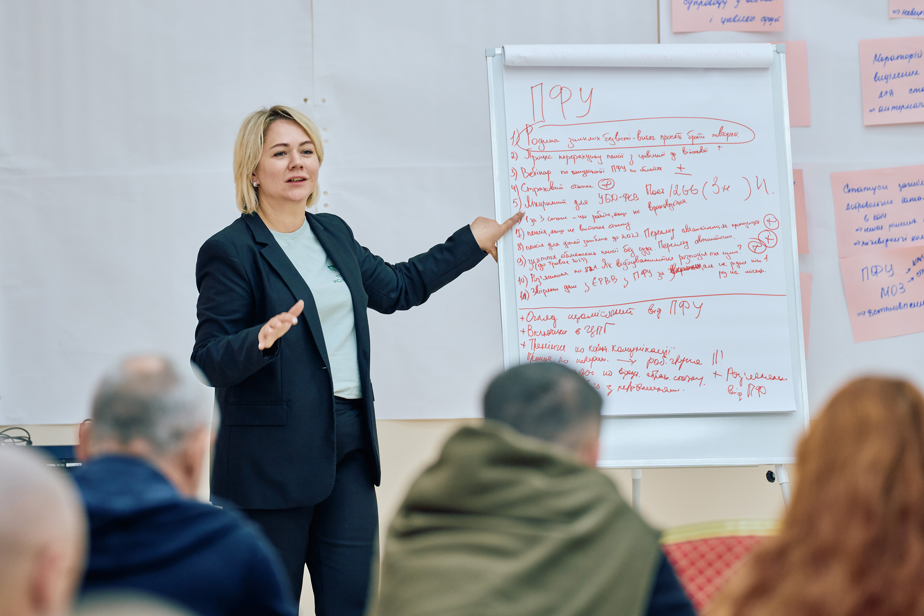 A woman presents in front of a room of people