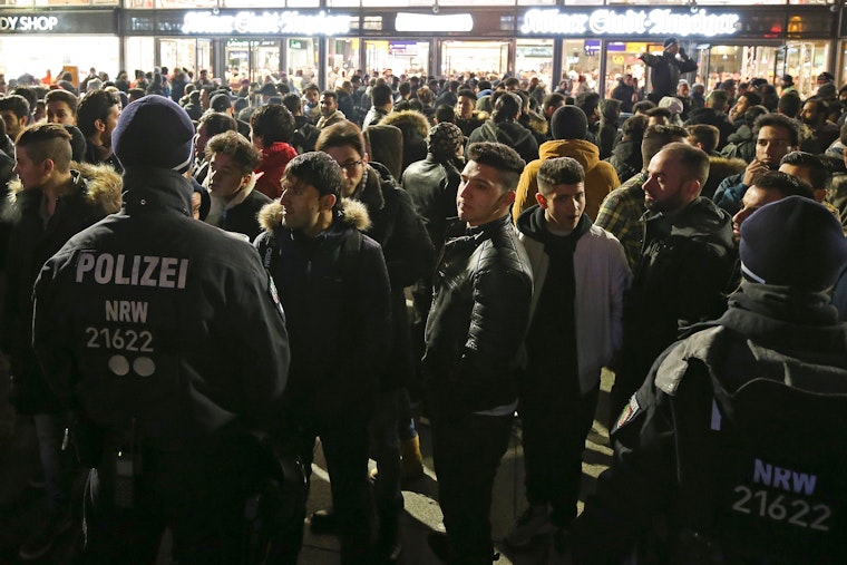 A large group of people stand in a plaza