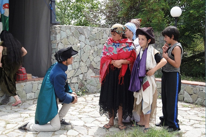 Participants in the Common Kids summer camp 2012 which took place outside Tbilisi, Georgia. By the end of the summer camp the children decided to perform a play that explored the themes of culture and discrimination. They performed a skit based on a novel by Cervantes whose caballero falls in love with a Roma girl. She tells him that she will marry him only if he agrees to live and travel with her family for a year. Photo credit: Katherine Lapham/Open Society Foundations Children performing a play.