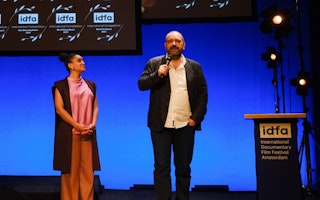 Orwa Nyrabia and a woman standing on a stage