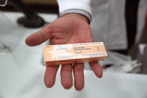 A hand displaying a pharmaceutical box