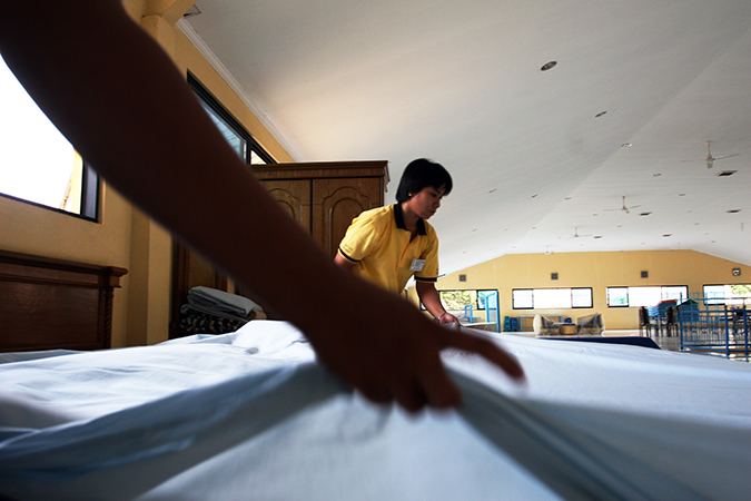 Two people making a bed