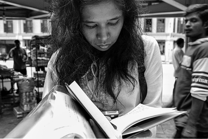 A woman with a book and phone