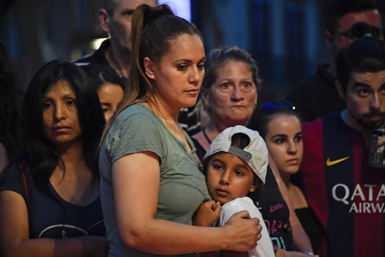 People stand at a makeshift memorial in Barcelona, Spain, on August 18, 2017. Photo credit: © Pascal Guyot/Getty A group of people mourning