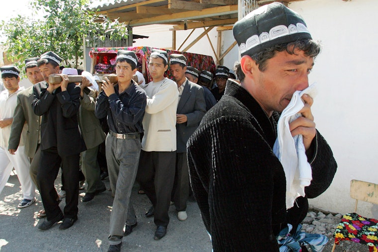 On May 15, 2005, a relative mourns at the funeral of one of the estimated 500 people killed by Uzbek troops in the city of Andijan. Photo credit: © Shamil Zhumatov/Corbis Casket attended by mourners