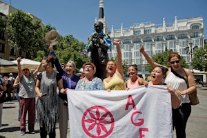 A group of women celebrating and holding a banner