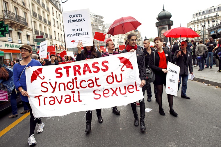 Sex workers and their allies march in Paris streets in October 2013 to oppose proposed legislation that would penalize the clients of sex workers. Protesters carry a banner featuring STRASS, a sex worker trade union. Photo credit: © Thomas Samson/Getty Demonstators in Paris