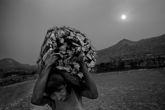 Man carrying wood on his shoulder