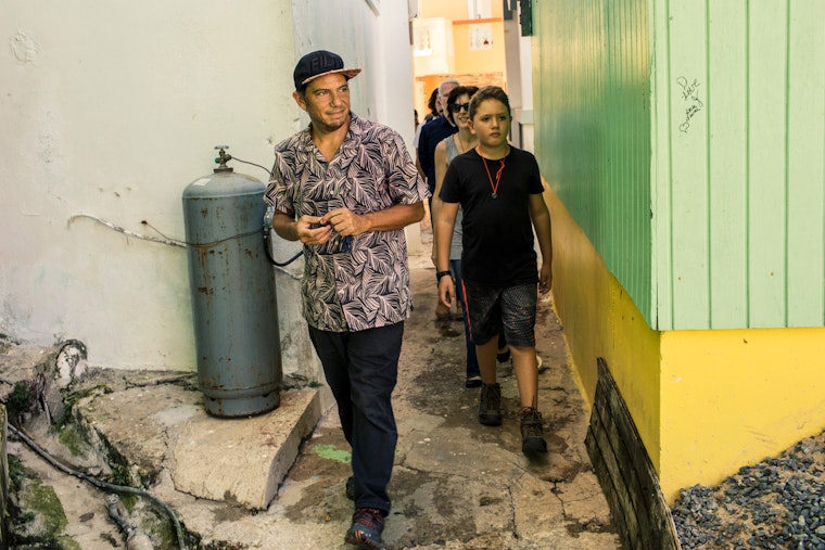 Two people walk through buildings.