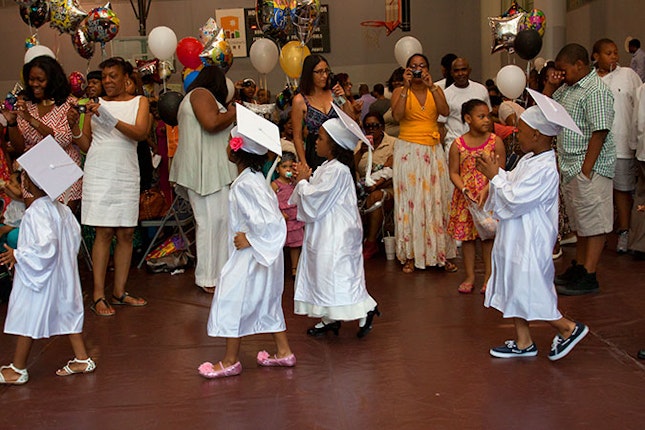 Children wearing cap and gowns.