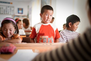 Children in an english class in Tort-Kul, Kyrgyzstan, in 2009. Photo credit: © Malte Jaeger/laif/Redux A child standing at a desk in a classroom