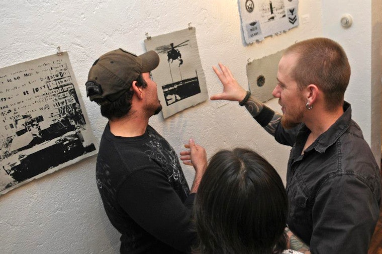 People looking at artwork on a wall.