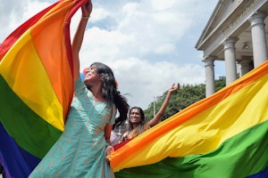 People dancing with rainbow flag