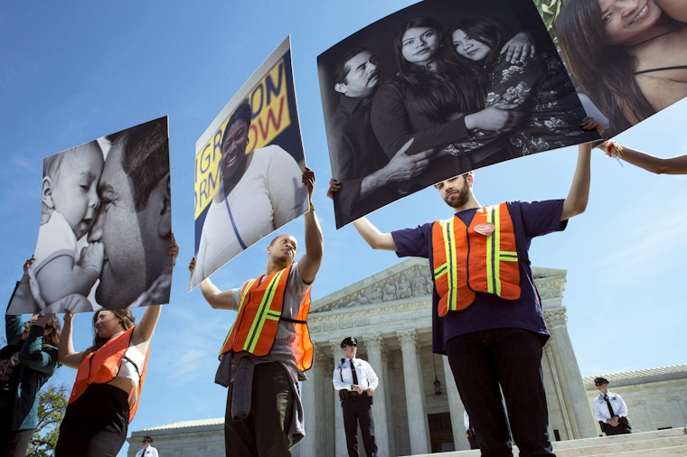 Demonstrators holding up family portraits