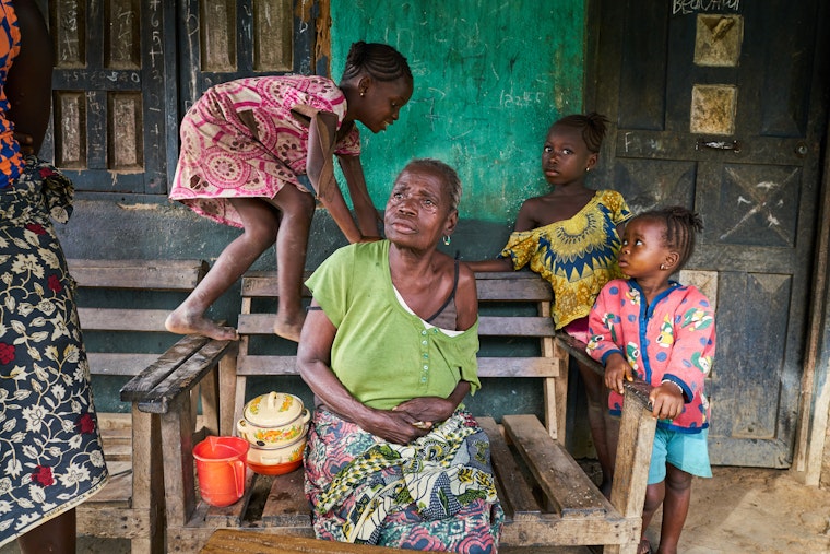 An elderly woman surrounded by children