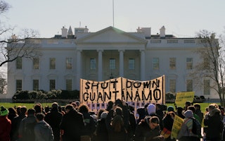 A large banner in front of the White House that says “Shut Down Guantanamo”
