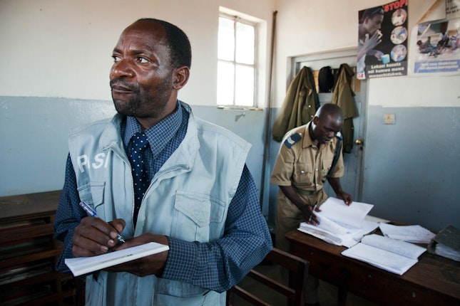Two men with paperwork inside a police station