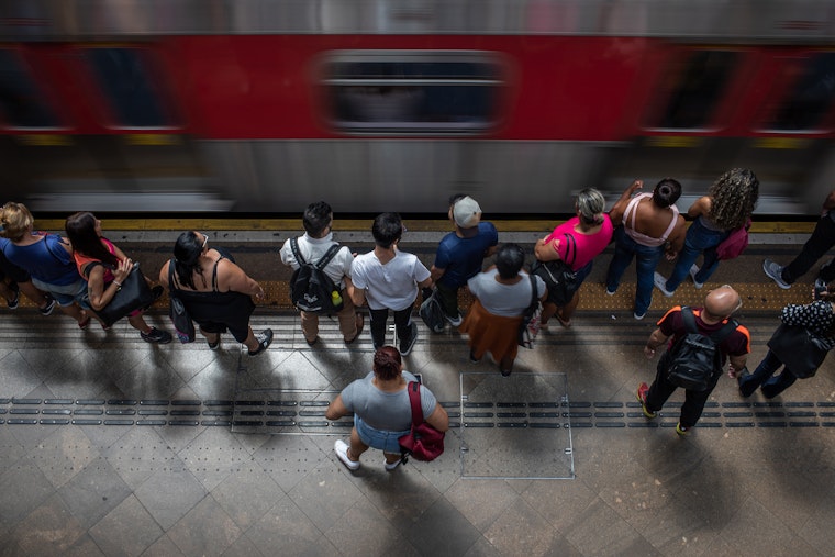 Pessoas vistas de cima, próximas a um trem.