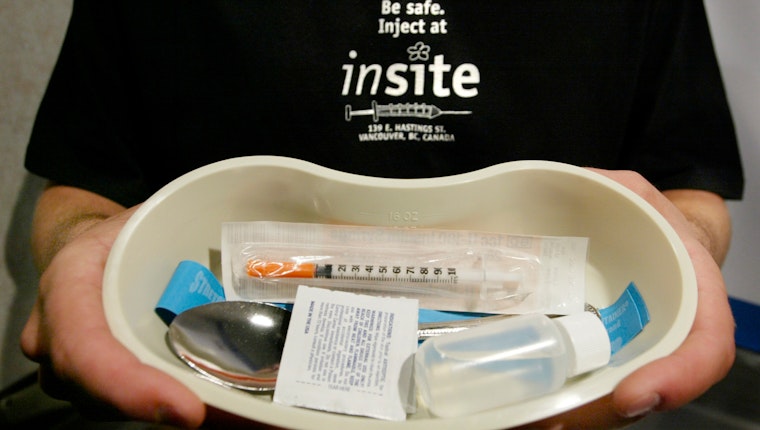 A person holding a tray with supplies