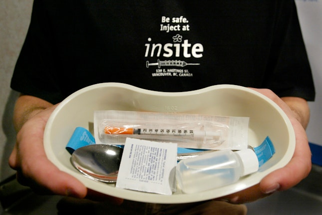 A person holding a tray with supplies