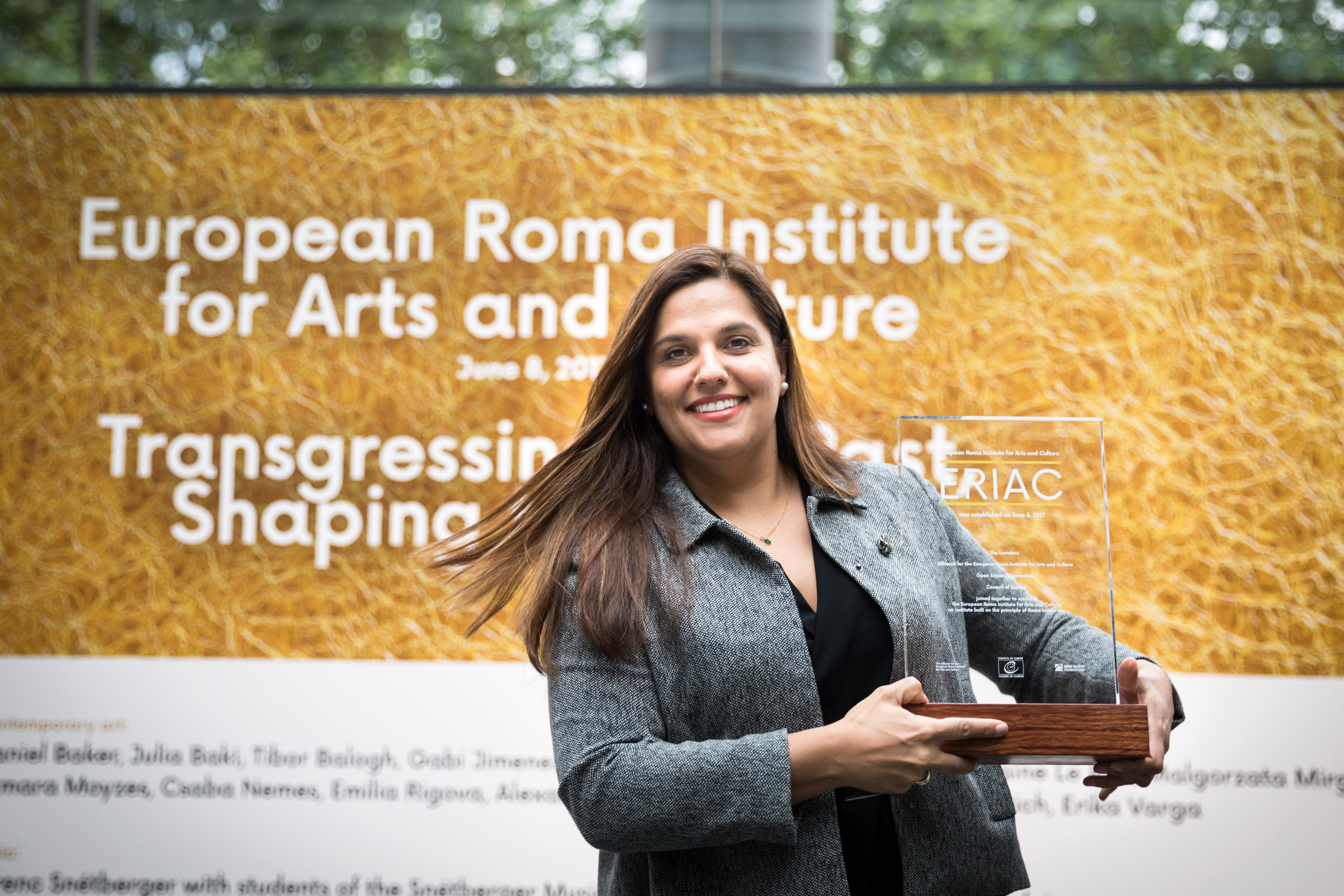 Woman smiling holding plaque