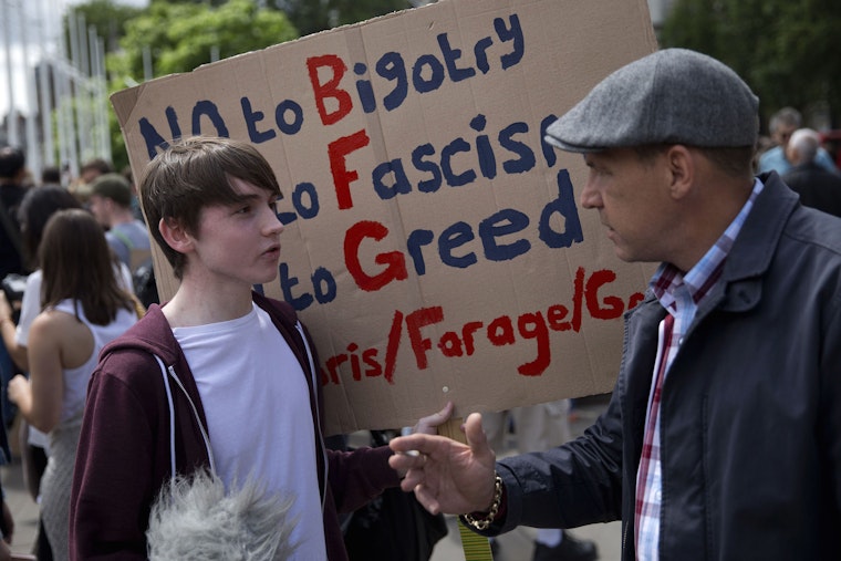 A demonstrator speaks with a pedestrian during a protest in London against the pro-Brexit outcome of the UK’s referendum on the European Union on June 25, 2016. Photo credit: © Justin Tallis/AFP/Getty Demonstrator holding a sign