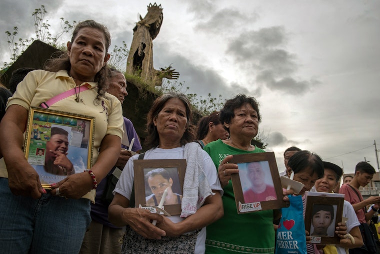 A group of people standing in mourning