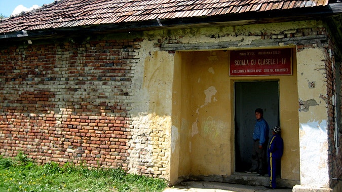 Two people standing outside door to building