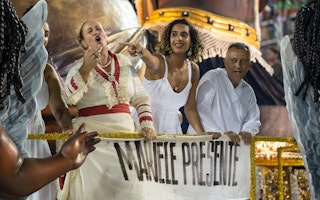 Anielle Franco e outros em um carro alegórico em um desfile.