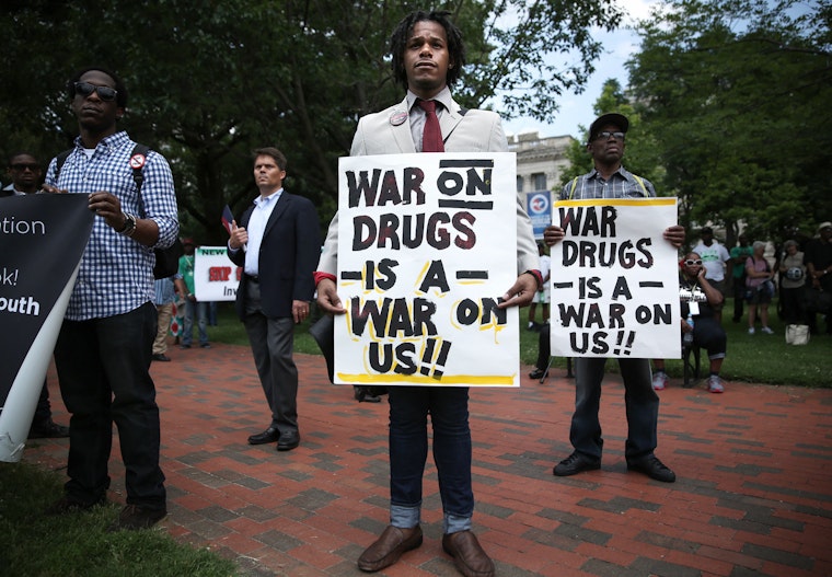 People holding signs that read "war on drugs is a war on us"