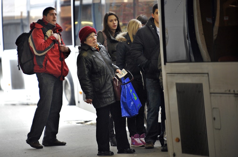 Local residents wait for a bus in Budapest on January 13, 2010. Photo credit: © Atilla Kisbenedek/Getty People wait to board a bus