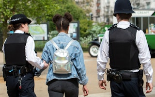 Two police officers arresting a woman