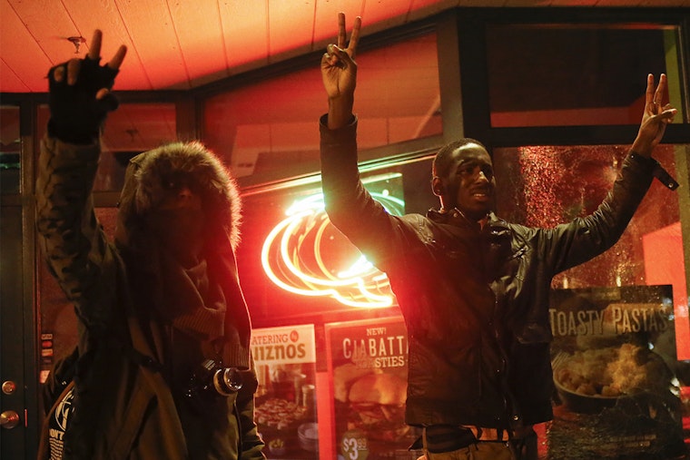 Men try to stop protesters from throwing rocks at local businesses after authorities announced that a grand jury voted not to indict a white officer in the August shooting of Michael Brown in Ferguson, Missouri. Photo credit: © Adrees Latif/Reuters Men hold hands up