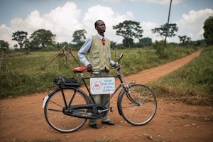 A man standing next to bicycle