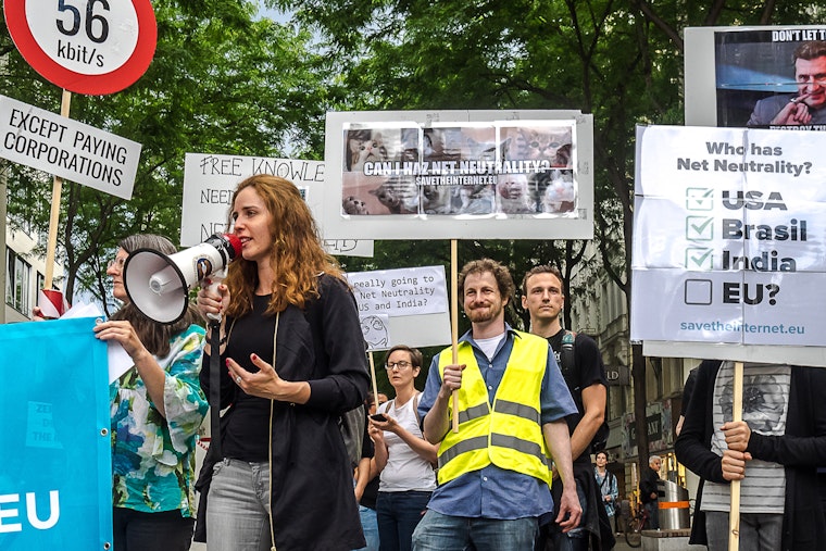 Supporters of a free and open internet gather during an outdoor demonstration.