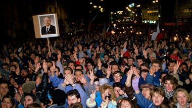 A large crowd at a demonstration in a street at night