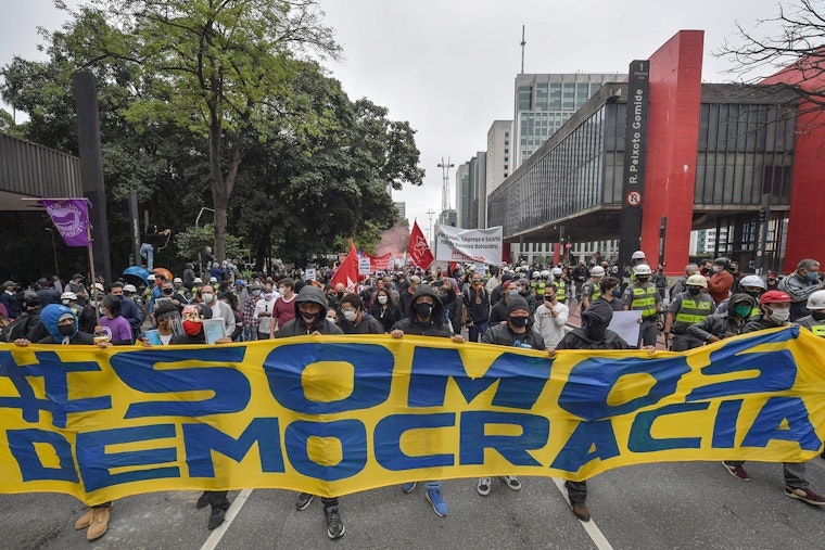 Protestors marching in the street with a banner