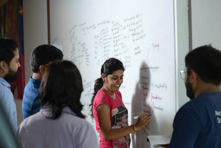 The designers of an app to connect customers and financial institutions discuss artificial intelligence in Bengaluru, India, on April 27, 2017. Photo credit: © Hemant Mishra/Mint/Getty a group of people around a dry erase board