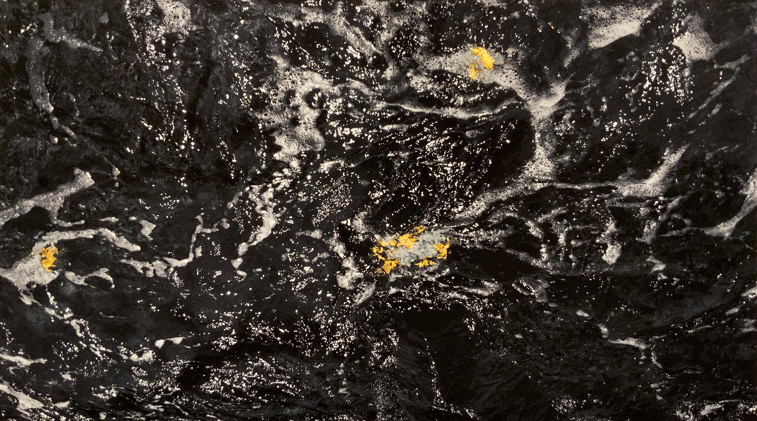 Black and white image of water with collaged gold leaf.