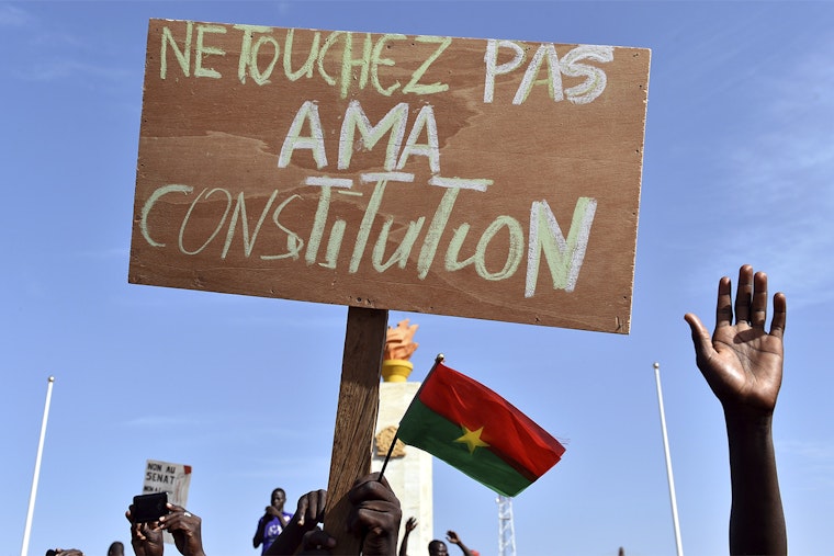 Burkina Faso’s opposition supporters hold a sign that reads in French, “Don’t touch our constitution,” as they take part in a protest on October 28, 2014, in Ouagadougou against a proposal to amend the constitution to extend President Blaise Compaore’s 27-year-rule. Burkina Faso braced for a week of sweeping protests linked to a controversial vote to allow the country’s long-serving president to extend his rule beyond 30 years. Photo credit: Issouf Sanogo/AFP/Getty Images Protest sign in French