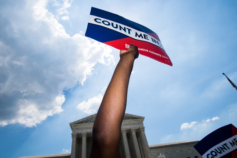 Protestors hold up signs