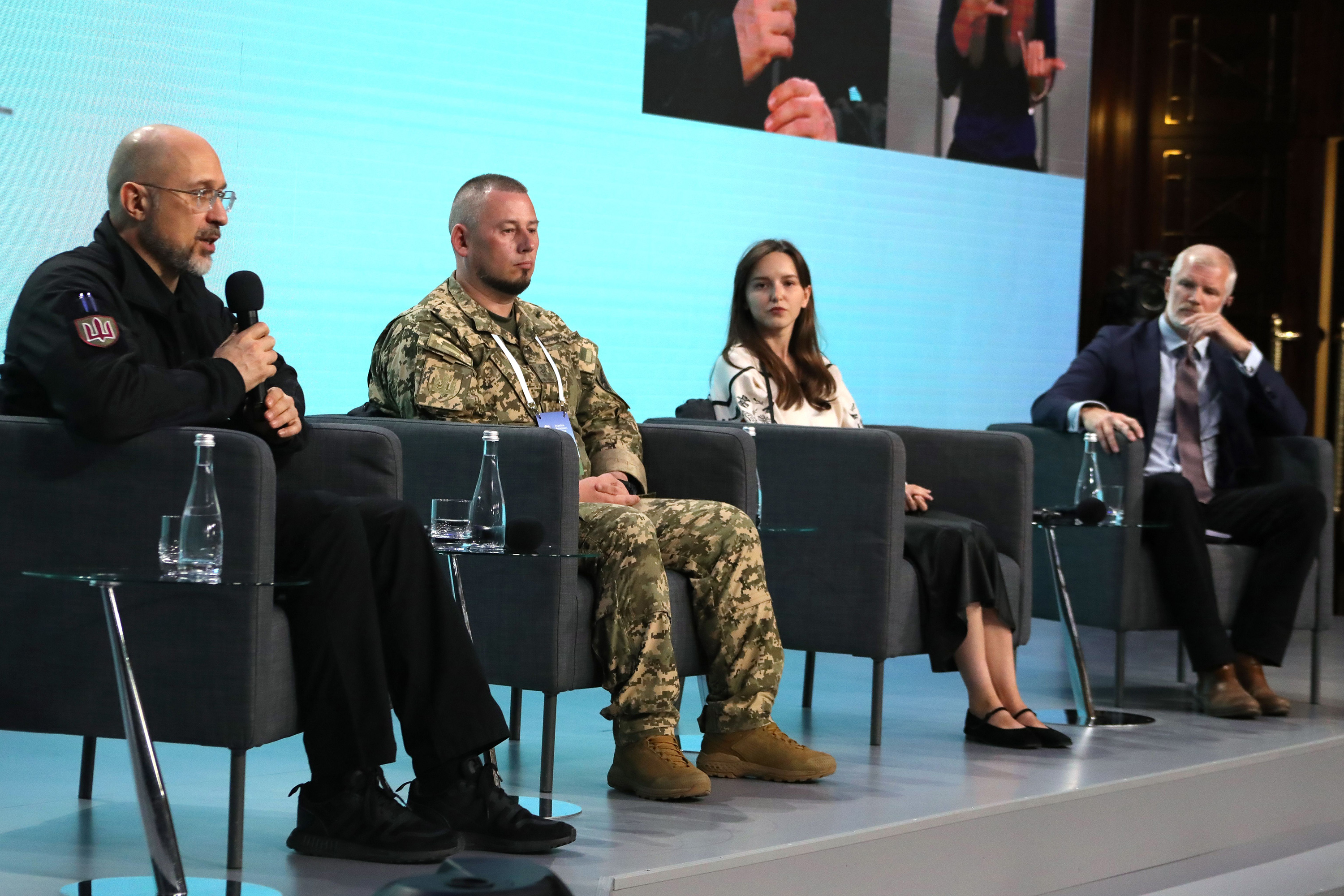 A group of four people sit on stage for a panel discussion