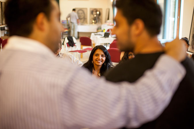A woman watching two men talk.