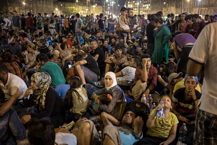 crowd of migrants at night outside a Budapest train station