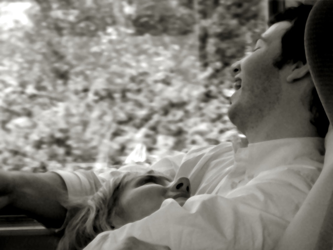 Man looking out window, laughing.